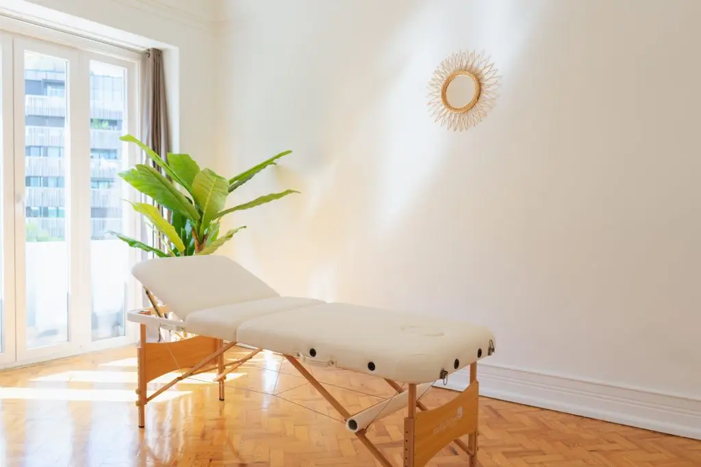 Marquesa de massagem com planta e luz natural, sala de massagem em Lisboa