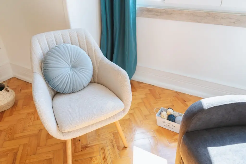Poltrona com almofada azul em soalho de parquet, numa sala de reunião em Lisboa