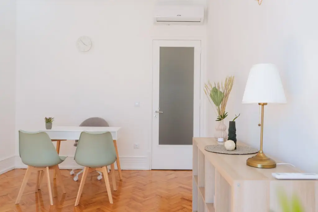 Sala de reunião em Lisboa com mesa, cadeiras verdes e candeeiro