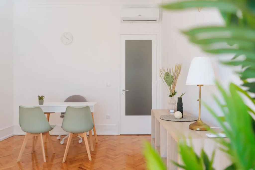 Consultório em Lisboa com decoração minimalista, secretária, cadeiras verde-água e candeeiro