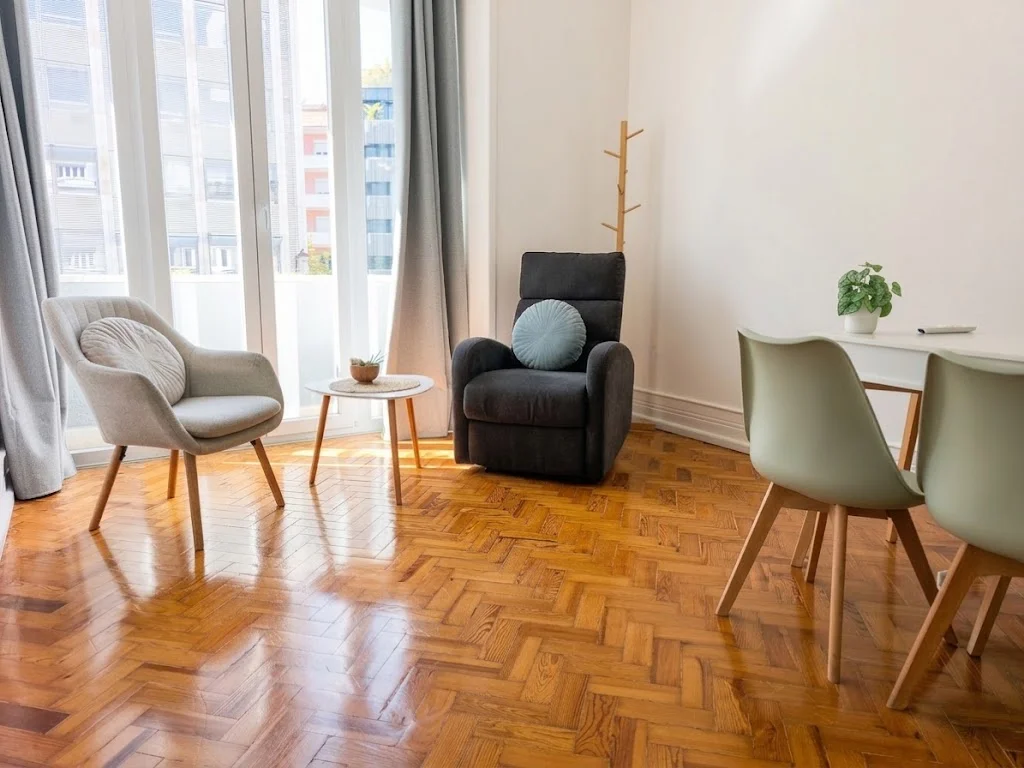 Consultório em Lisboa com cadeirão reclinável, poltronas e mesa, com luz natural